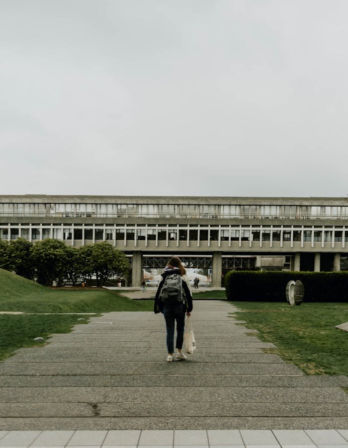 A woman with a backpack walking on Simon Fraser University campus, Burnaby, Canada.